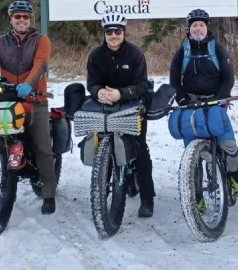 Three riders with heavily loaded fat bikes during a winter bikepacking trip