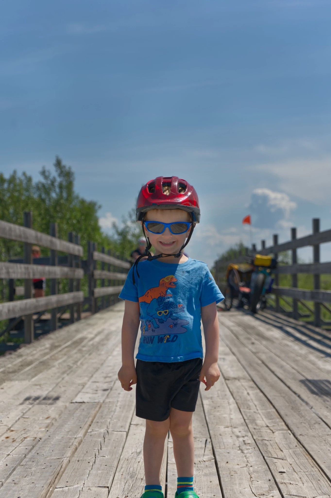Young bikepacker standing on a wooden railway trestle along the Donalda route