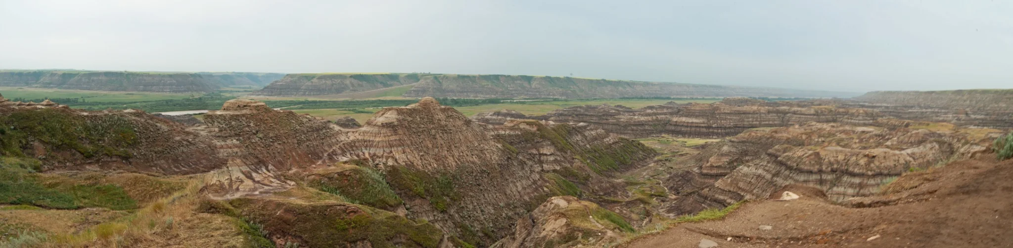 Wide panoramic view across layered badlands terrain at Horsethief Canyon