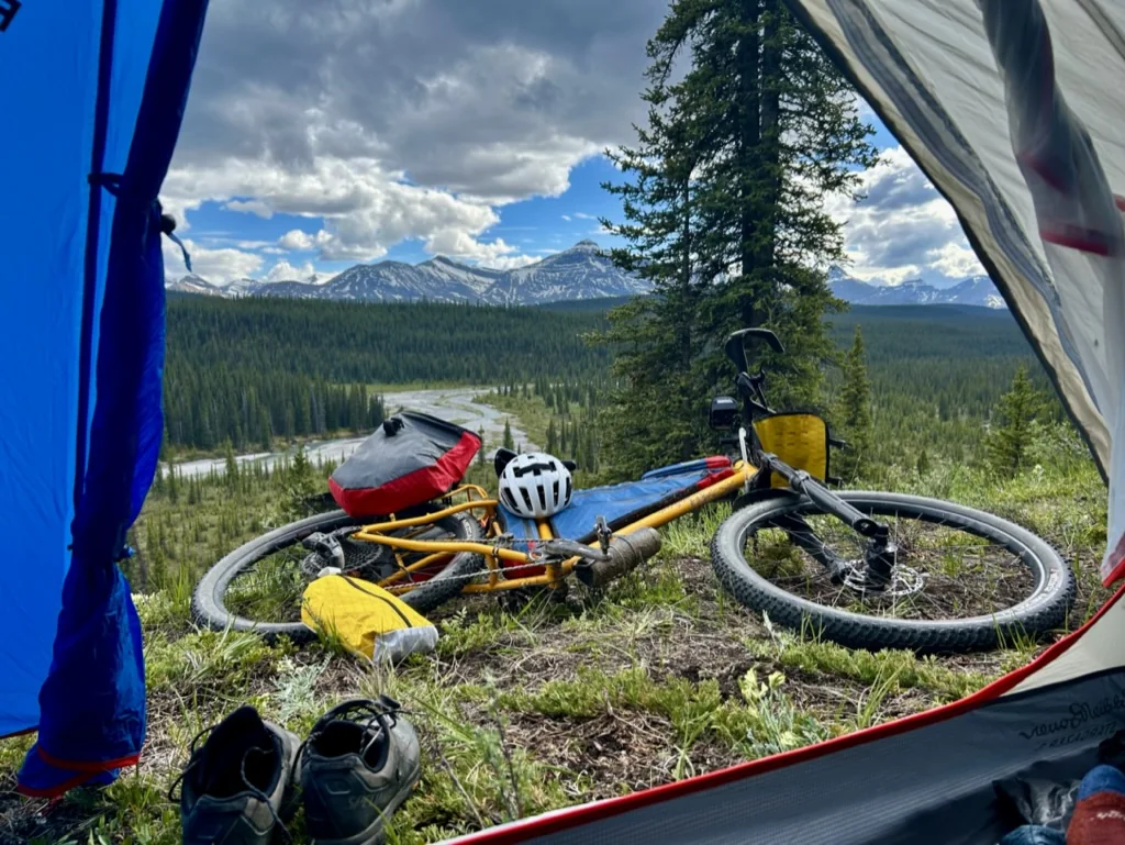 Loaded bike beside a tent at a remote mountain camp
